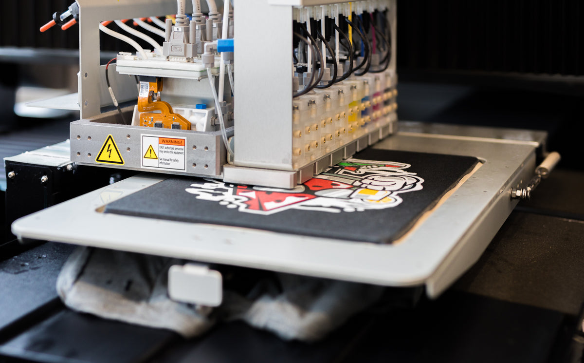Direct-to-garment printer laying a colour graphic onto a dark tee