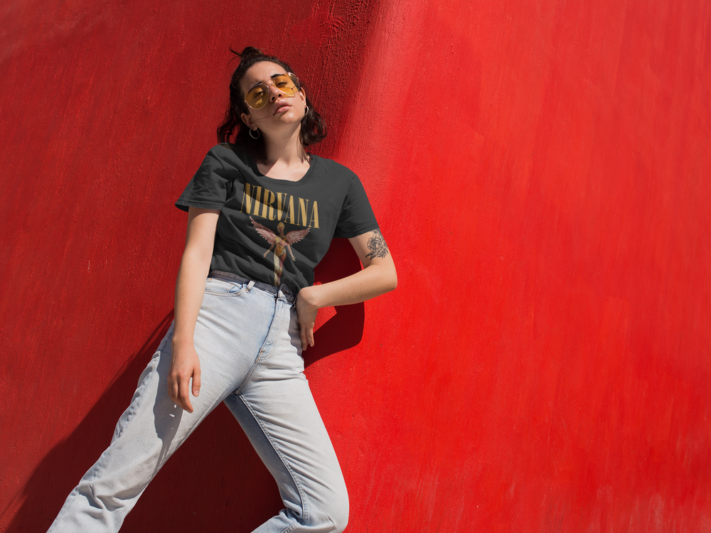 Music People — black Nirvana band tee with light jeans, against a red wall