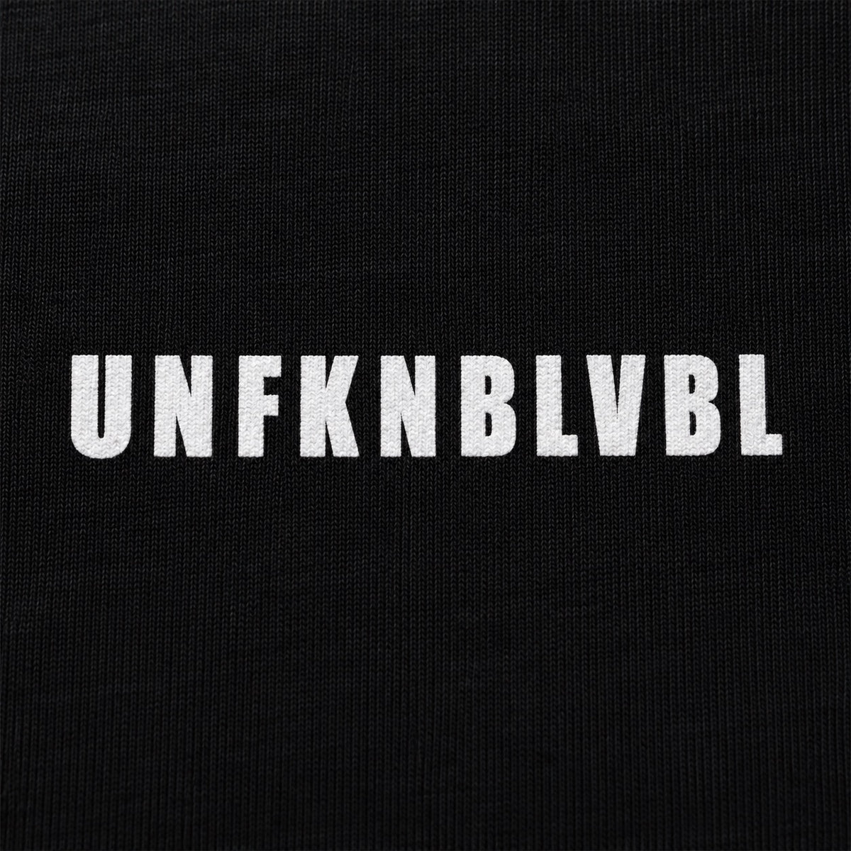 UNFKNBLVBL white condensed lettering, cotton print close-up